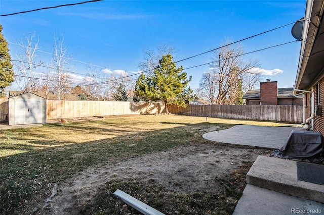 view of yard with an outbuilding, a fenced backyard, a shed, and a patio