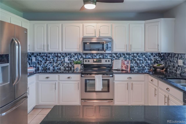 9927 Aftonwood St, Highlands Ranch, CO 80126 - kitchen featuring stainless steel appliances, white cabinets, dark stone countertops, and light tile patterned flooring