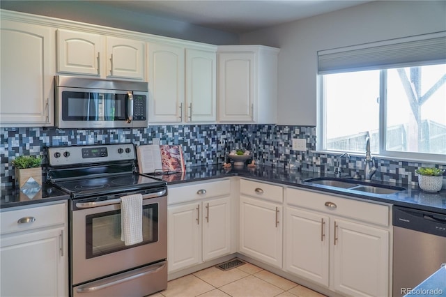 9927 Aftonwood St, Highlands Ranch, CO 80126 - kitchen with stainless steel appliances, white cabinets, decorative backsplash, and light tile patterned flooring