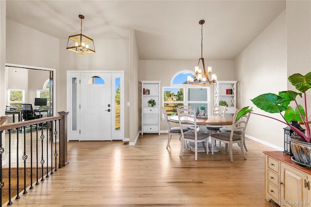 foyer featuring light hardwood / wood-style floors, lofted ceiling, and a chandelier