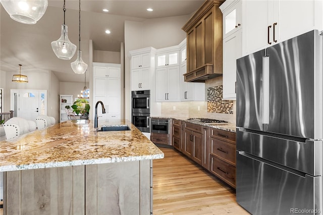 kitchen with white cabinetry, a large island with sink, stainless steel appliances, and sink