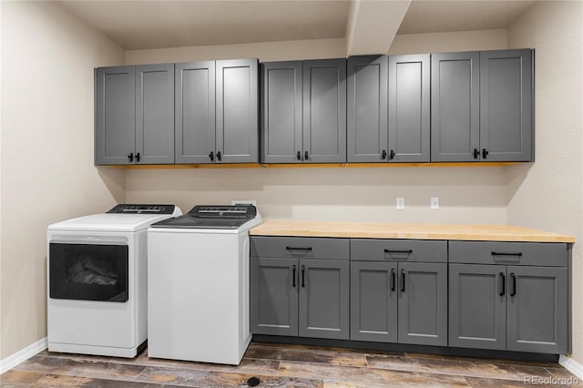 laundry area featuring cabinets, dark hardwood / wood-style floors, and washing machine and dryer