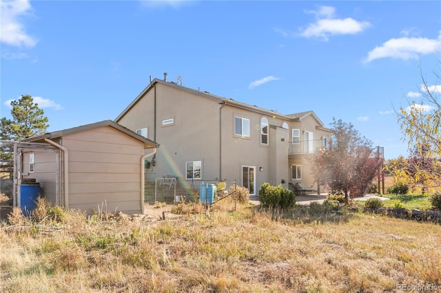 back of property featuring a balcony