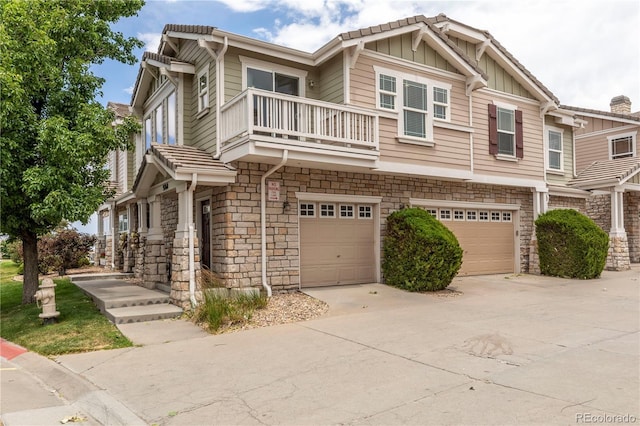 9760 Mayfair St Unit A, Englewood, CO 80112 - townhome / multi-family property with a balcony, a garage, stone siding, driveway, and board and batten siding