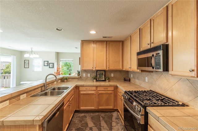 9760 Mayfair St Unit A, Englewood, CO 80112 - kitchen with stainless steel appliances, tile counters, a peninsula, recessed lighting, and light brown cabinetry