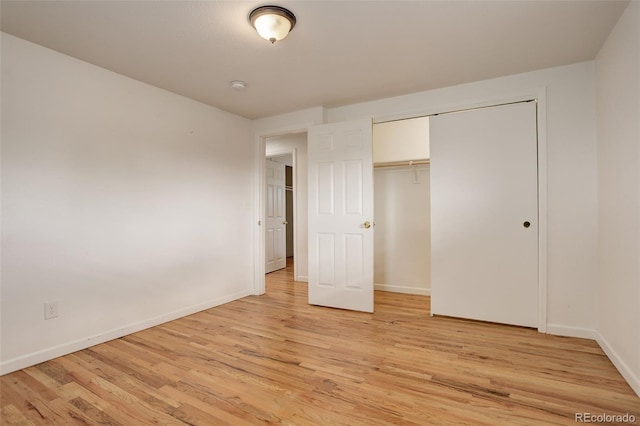 unfurnished bedroom with light hardwood / wood-style flooring and a closet