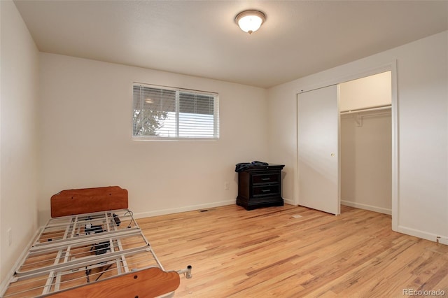 bedroom with light hardwood / wood-style flooring and a closet