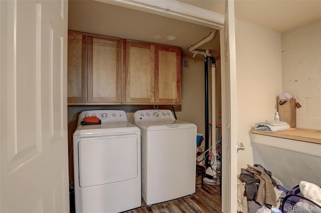 laundry room featuring hardwood / wood-style flooring, cabinets, and washing machine and clothes dryer