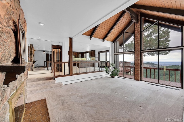 unfurnished living room featuring beamed ceiling, baseboard heating, carpet, and wooden ceiling