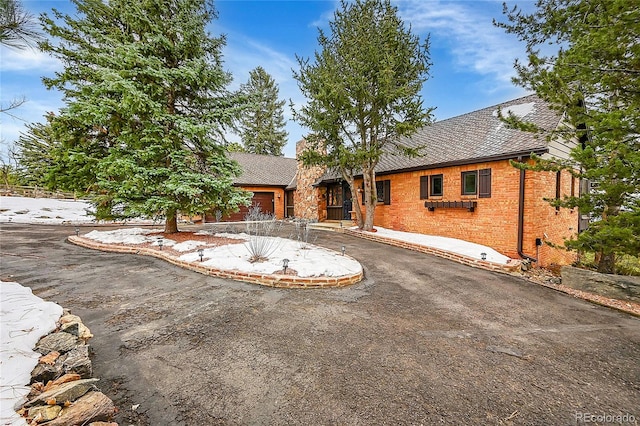 view of front facade featuring brick siding and driveway