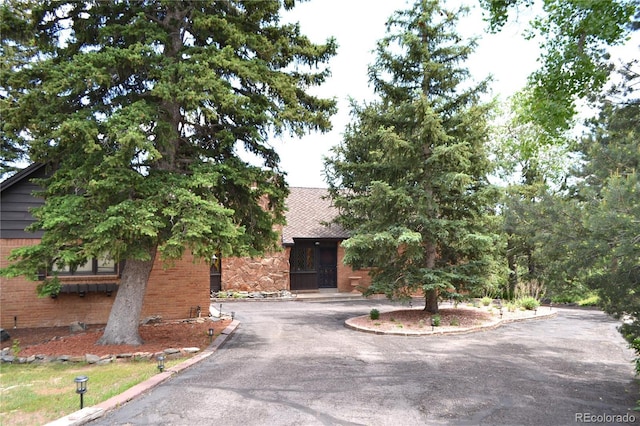 21849 Cabrini Blvd, Golden, CO 80401 - obstructed view of property featuring brick siding and asphalt driveway