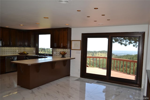 21849 Cabrini Blvd, Golden, CO 80401 - kitchen with dishwasher, tasteful backsplash, a peninsula, a breakfast bar, and dark brown cabinets