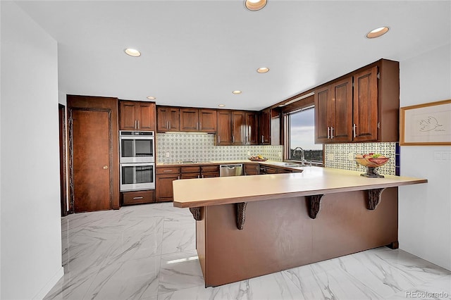 21849 Cabrini Blvd, Golden, CO 80401 - kitchen featuring stainless steel appliances, recessed lighting, light countertops, a peninsula, and a breakfast bar