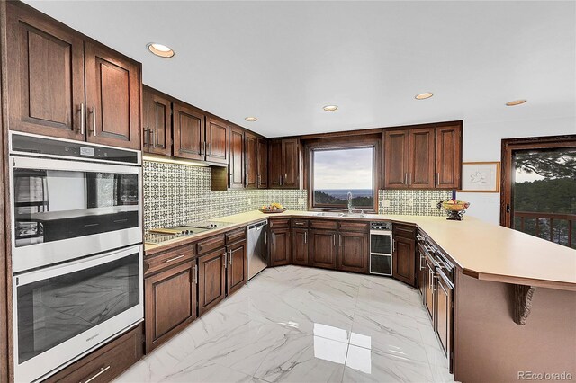 21849 Cabrini Blvd, Golden, CO 80401 - kitchen with stainless steel appliances, a peninsula, light countertops, recessed lighting, and backsplash