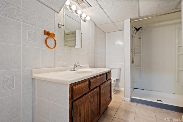 9350 Raleigh Ct, Westminster, CO 80031 - bathroom with tile patterned flooring, vanity, a shower stall, tile walls, and a paneled ceiling