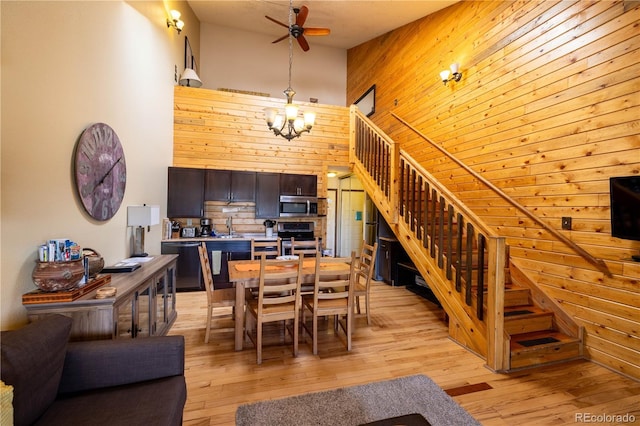 62927 US Highway 40 Unit 659, Granby, CO 80446 - dining area featuring stairs, ceiling fan, a high ceiling, light wood finished floors, and wooden walls