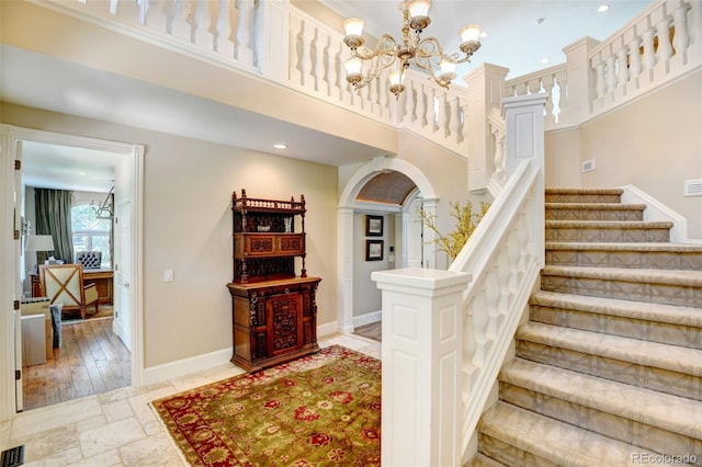 staircase featuring a notable chandelier and light hardwood / wood-style flooring