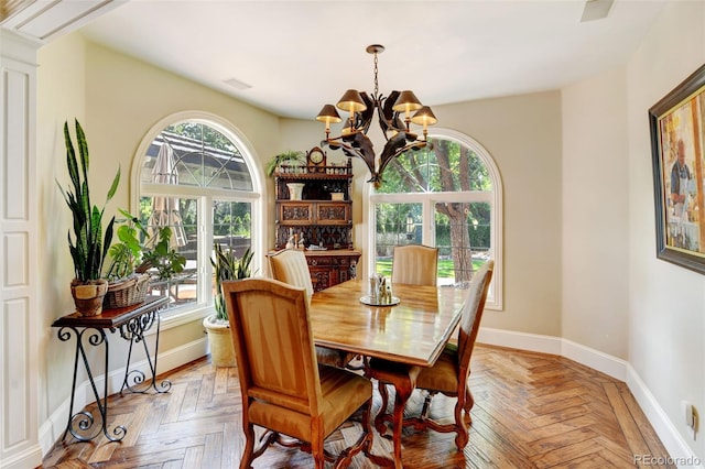 dining area with a notable chandelier and parquet floors