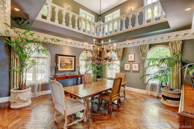 dining room featuring a towering ceiling, plenty of natural light, and light parquet floors