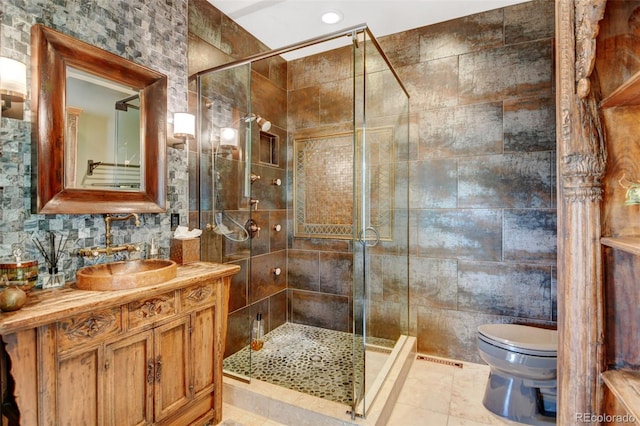 full bathroom with tiled shower, tile walls, toilet, and vanity