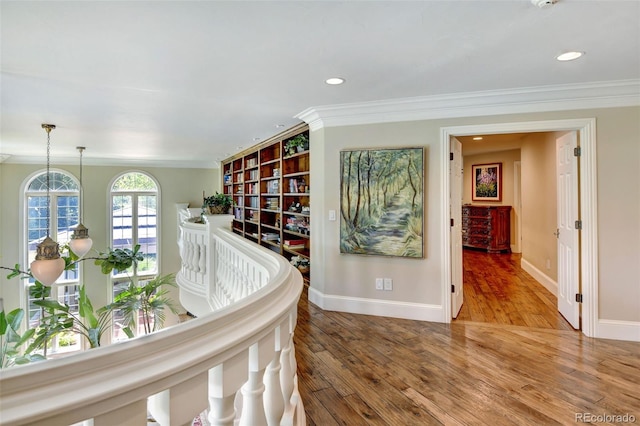 hallway featuring ornamental molding, recessed lighting, wood finished floors, and baseboards