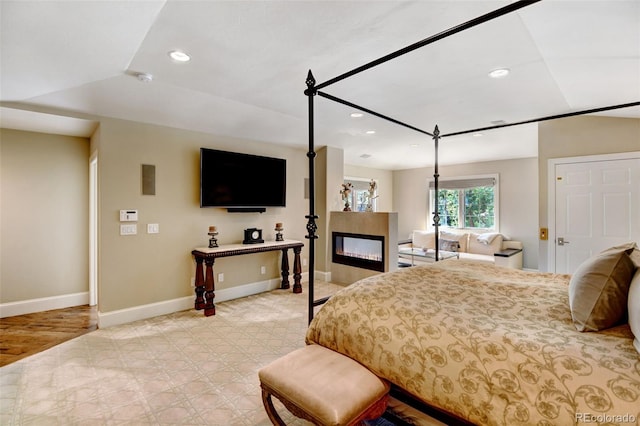 bedroom with light hardwood / wood-style flooring and lofted ceiling