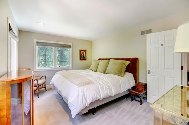 bedroom featuring visible vents and light carpet