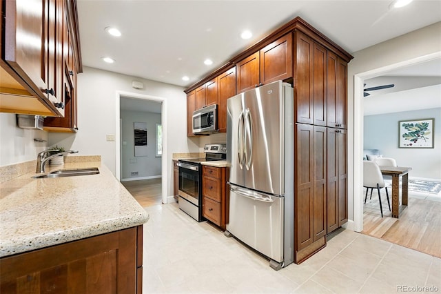 5436 E Atlantic Pl, Denver, CO 80222 - kitchen with stainless steel appliances, a sink, recessed lighting, light stone counters, and baseboards