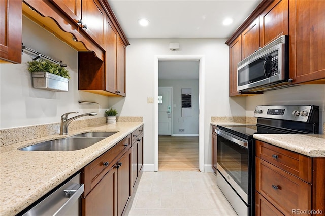 5436 E Atlantic Pl, Denver, CO 80222 - kitchen with appliances with stainless steel finishes, a sink, light stone counters, baseboards, and recessed lighting