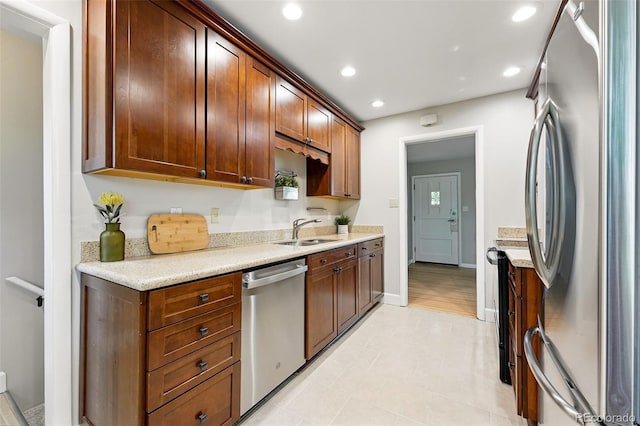 5436 E Atlantic Pl, Denver, CO 80222 - kitchen with appliances with stainless steel finishes, a sink, recessed lighting, baseboards, and light stone countertops