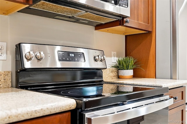 5436 E Atlantic Pl, Denver, CO 80222 - kitchen view of stainless steel electric range oven and brown cabinetry