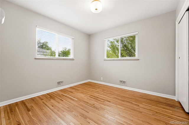 5436 E Atlantic Pl, Denver, CO 80222 - spare room featuring baseboards, light wood-type flooring, and an AC wall unit