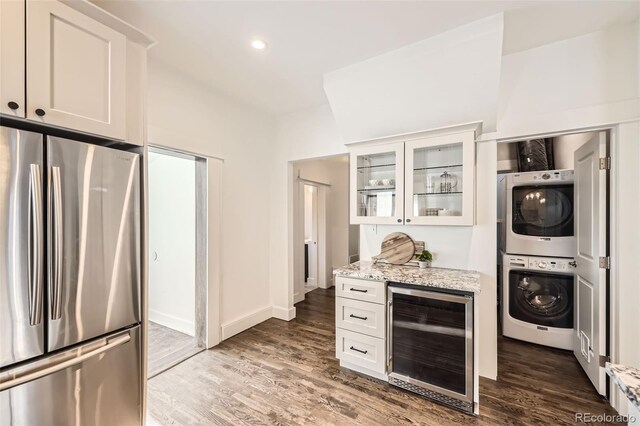 3521 Osage St, Denver, CO 80211 - kitchen featuring freestanding refrigerator, wine cooler, stacked washer / drying machine, light stone counters, and glass insert cabinets