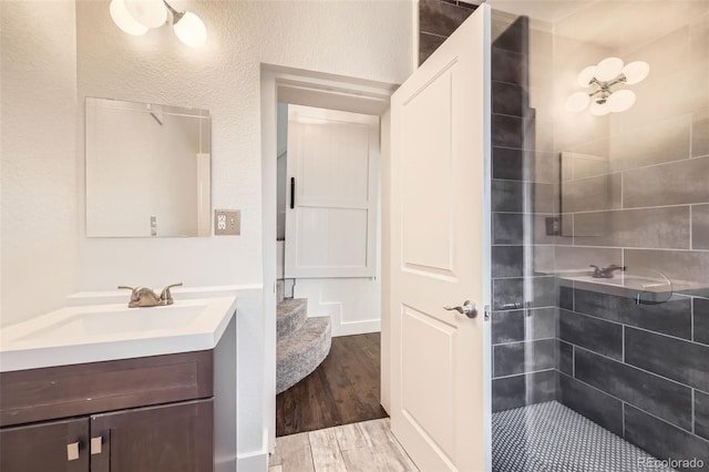 3521 Osage St, Denver, CO 80211 - full bathroom featuring vanity, a tile shower, and wood finished floors