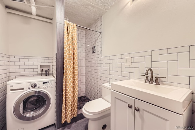 3521 Osage St, Denver, CO 80211 - full bath with tile walls, washer / clothes dryer, tiled shower, toilet, and a wainscoted wall