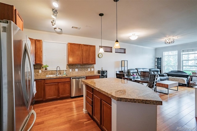 13456 Via Varra Unit 225, Broomfield, CO 80020 - kitchen with stainless steel appliances, light wood-style flooring, a center island, tasteful backsplash, and open floor plan