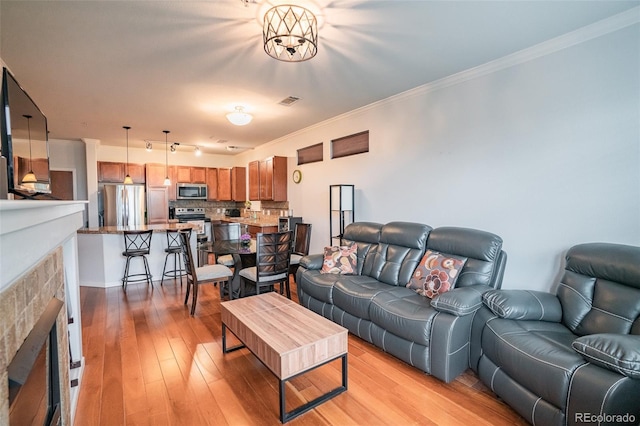 13456 Via Varra Unit 225, Broomfield, CO 80020 - living room featuring light wood finished floors, a fireplace, and ornamental molding