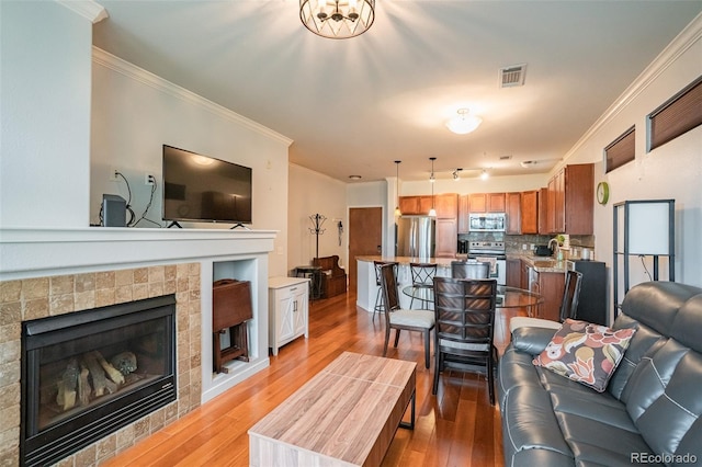 13456 Via Varra Unit 225, Broomfield, CO 80020 - living area featuring crown molding, light wood finished floors, and a fireplace