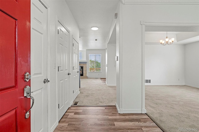 750 Capeglen Rd, Colorado Springs, CO 80906 - foyer with carpet floors, baseboards, a chandelier, and wood finished floors
