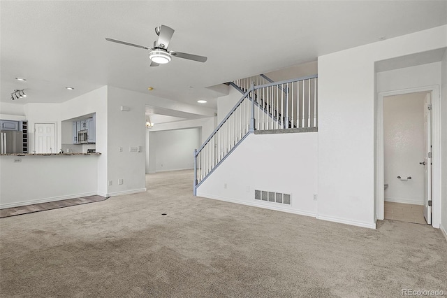750 Capeglen Rd, Colorado Springs, CO 80906 - unfurnished living room featuring carpet floors, a ceiling fan, baseboards, and stairs