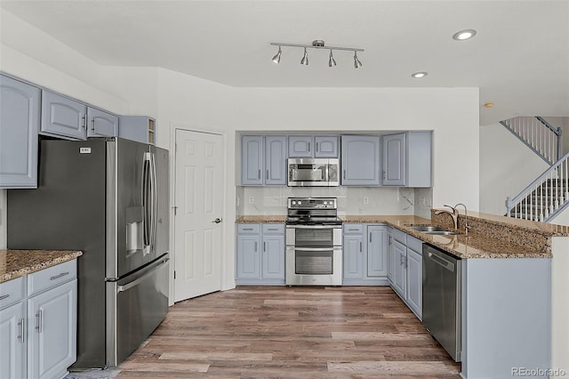 750 Capeglen Rd, Colorado Springs, CO 80906 - kitchen featuring appliances with stainless steel finishes, a sink, light stone counters, wood finished floors, and gray cabinets