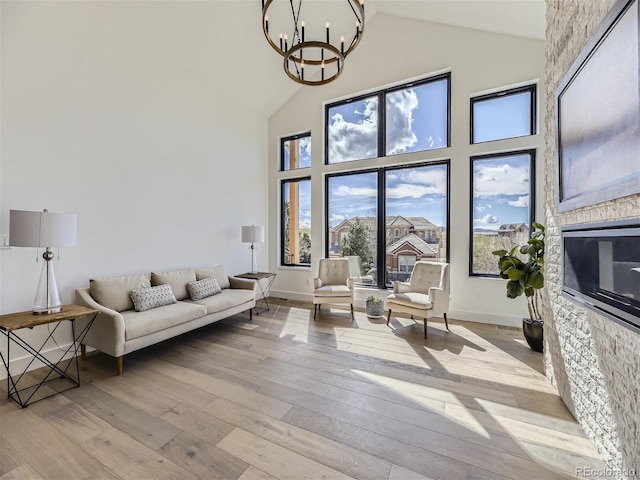 living room with plenty of natural light, light hardwood / wood-style floors, and high vaulted ceiling