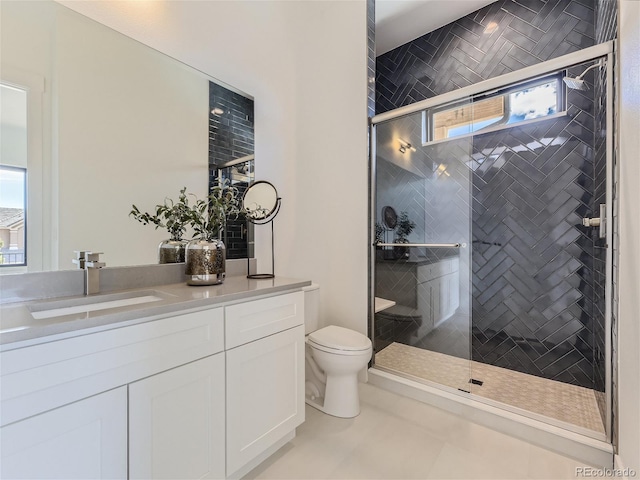 bathroom featuring tile floors, toilet, a shower with door, and a wealth of natural light