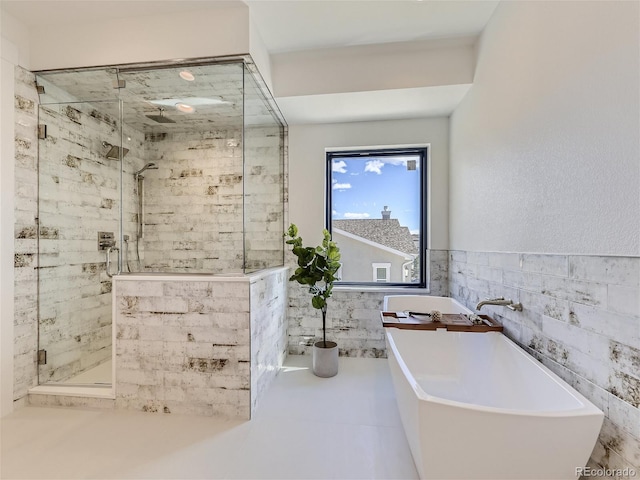 bathroom featuring tile flooring, tile walls, and plus walk in shower