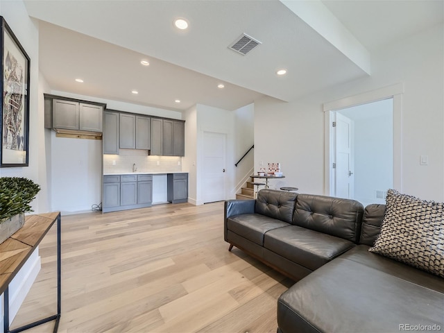 living room with sink and light wood-type flooring