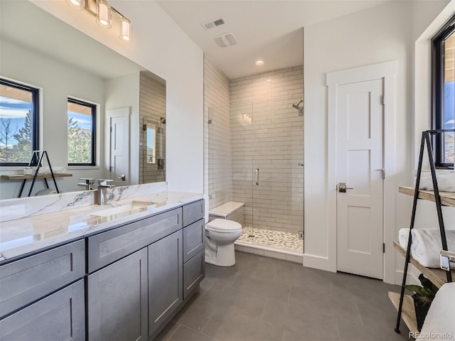 bathroom featuring a shower with door, toilet, tile flooring, and vanity