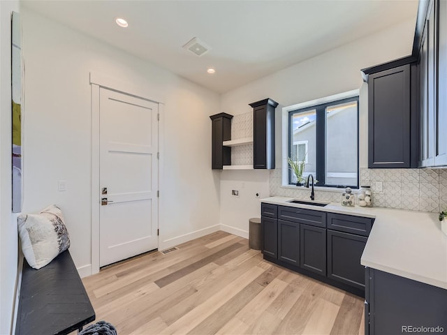 kitchen featuring tasteful backsplash, light hardwood / wood-style floors, and sink