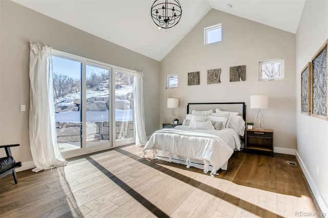 bedroom featuring wood-type flooring, access to outside, and multiple windows