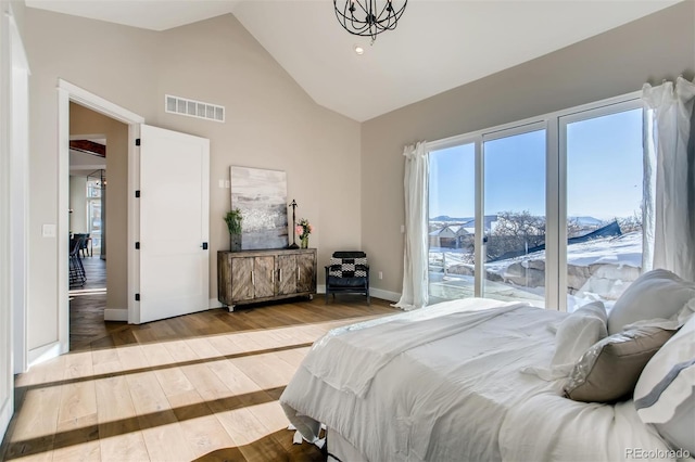 bedroom featuring high vaulted ceiling and hardwood / wood-style floors