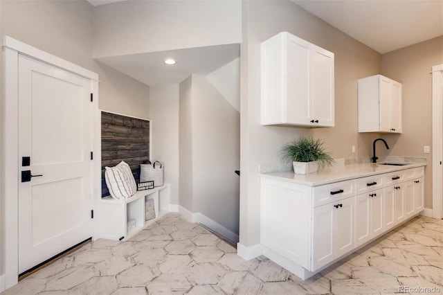 kitchen with white cabinets, sink, and light tile floors